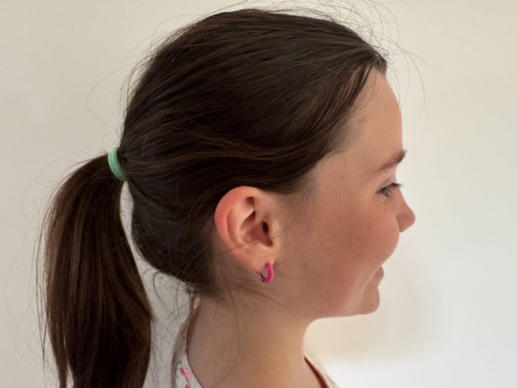 Tienermeisje draagt handgemaakte oorbellen van F-enne – stijlvolle en nikkelvrije sieraden met een persoonlijk verhaal